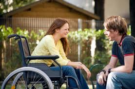 Man talking to woman sitting in a wheelchair.